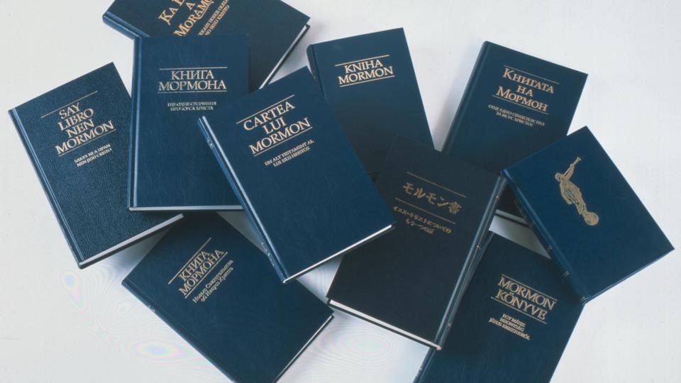 A haphazard pile of The Book of Mormon in different languages